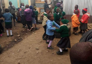 Zdjęcie przedstawia kenijskie podwórko na którym bawią się dzieci.